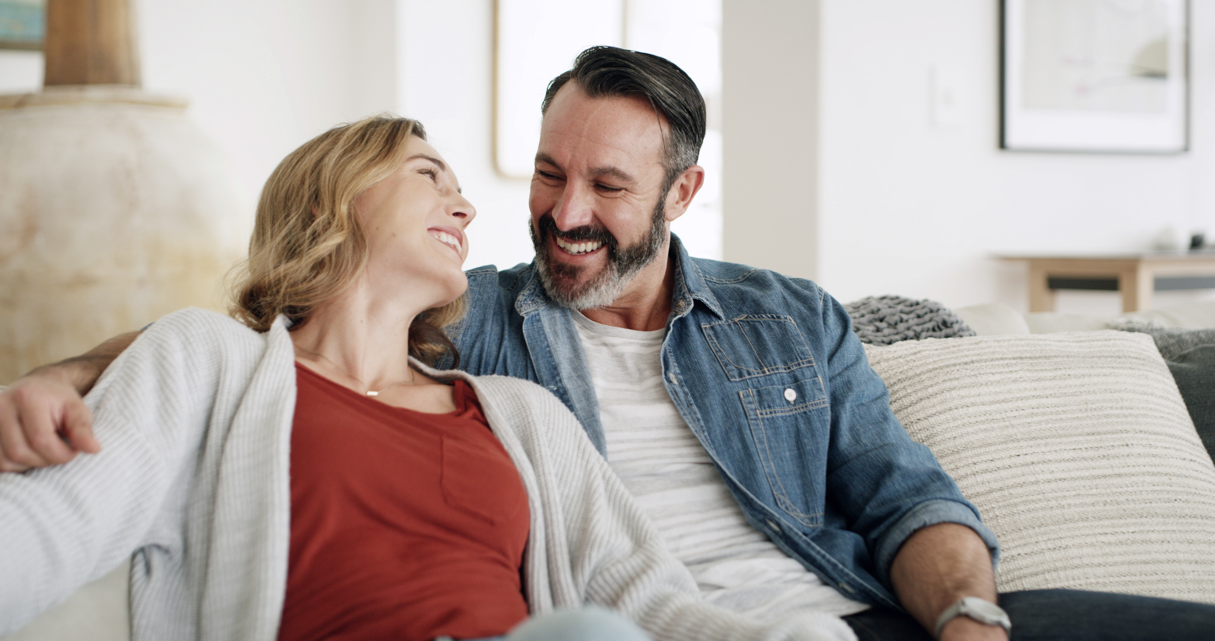 Homem feliz com parceira no sofá